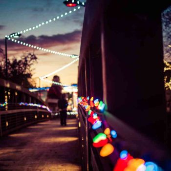 Christmas lights dance across a bridge over the San Marcos river