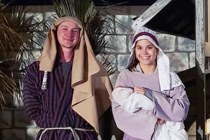 Volunteers dressed as Mary and Joseph pose in front of a manger at the Town of Bethlehem.