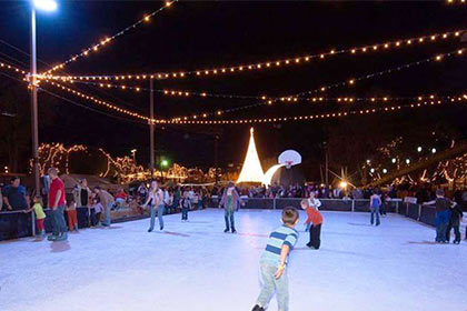 Beautiful Christmas lights provide a gorgeous backdrop to the ice skating rink.