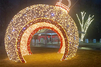 A giant ornament covered in Christmas lights brightens up the festival grounds.